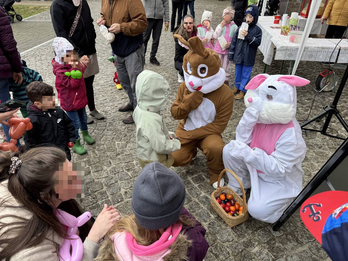 Das Foto zeigt zwei verkleidete Menschen in einem Hasenkostüm, um sie herum sind viele Kinder. 