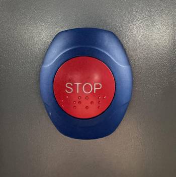 Das Foto zeigt einen blauen Schalter mit einem roten Knopf, auf dem "Stop" steht.