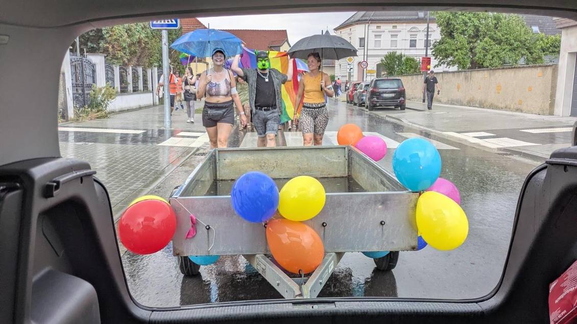 Das Foto zeigt mehrere Personen mit Regenschirmen.