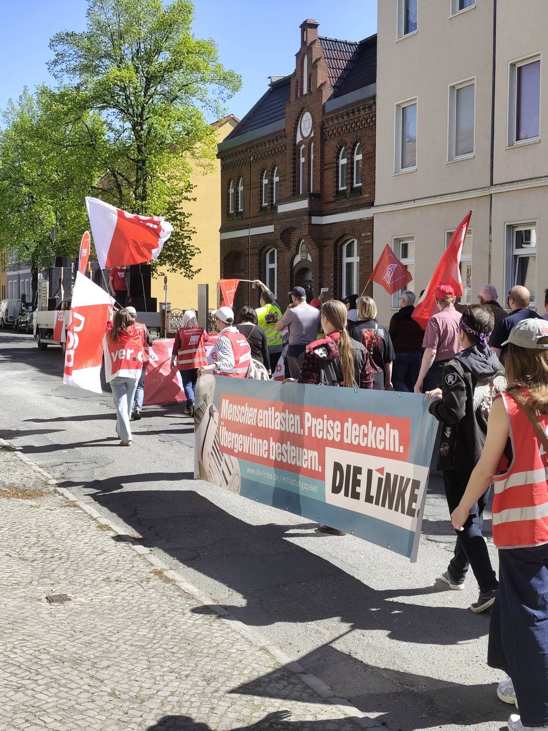 Das Foto zeigt mehrere Personen, die ein Banner der Linken tragen.