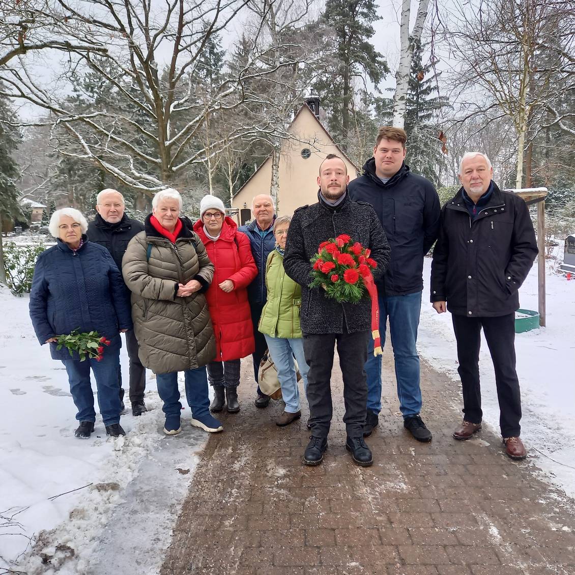 Das Foto zeigt mehrere Personen beim Holocaustgedenken auf dem Friedhof in Ludwigsfelde.