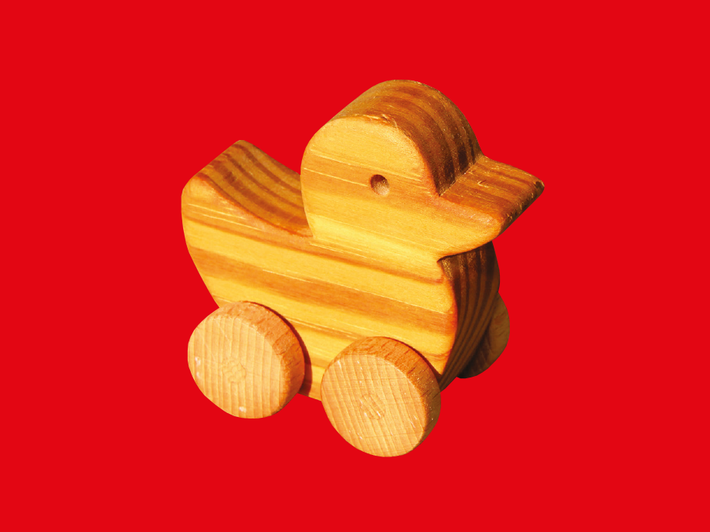 Die Grafik zeigt eine Spielzeugente aus Holz vor einem roten Hintergrund.